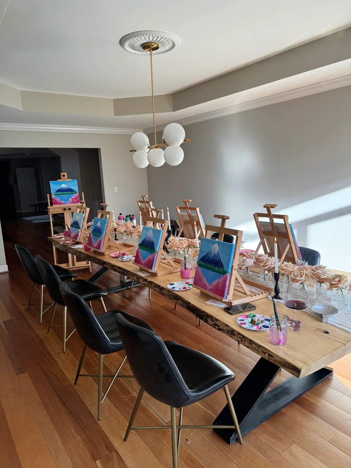 Easels and loaded palettes in window light before guests arrive at a Mind & Body Retreats art workshop