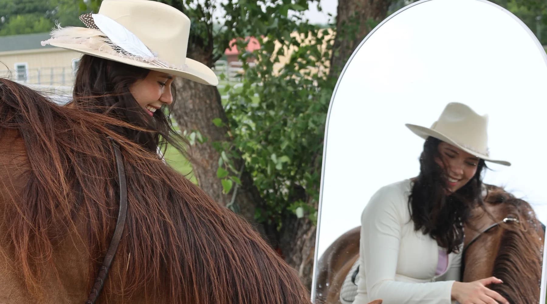 Guest in a feathered cowboy hat smiling beside a chestnut horse at the styled mirror photo moment during a Mind & Body Retreats Horses & Pilates event in Leesburg, Virginia